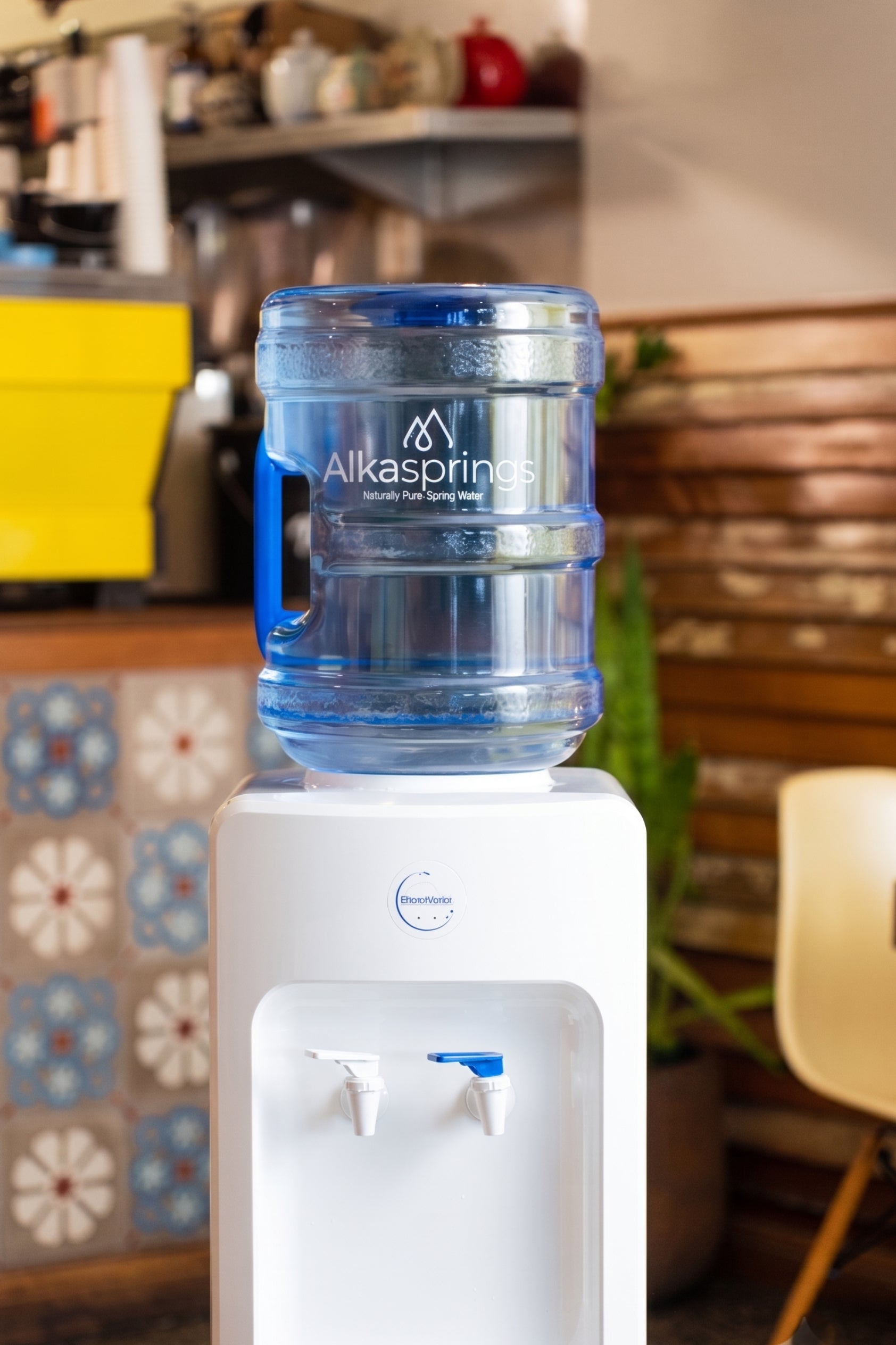 Alkasprings spring water bottle on a water cooler in a cafe
